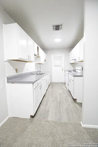 a kitchen with stainless steel appliances granite countertop a sink and cabinets