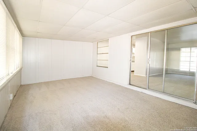 an empty room with cabinet and mirrors