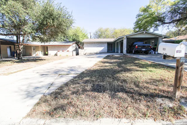 a view of a house with a yard and a tree