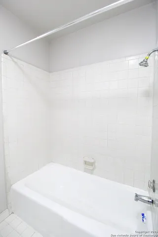 a bathroom with a white bath tub and a sink