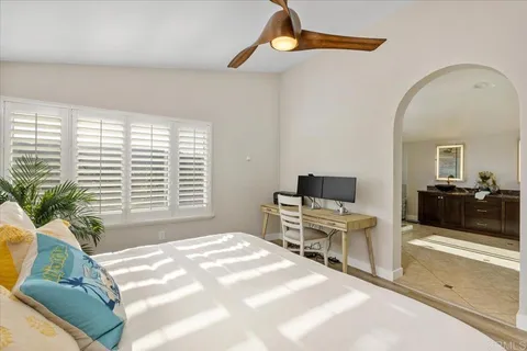 a bedroom with a bed and large windows