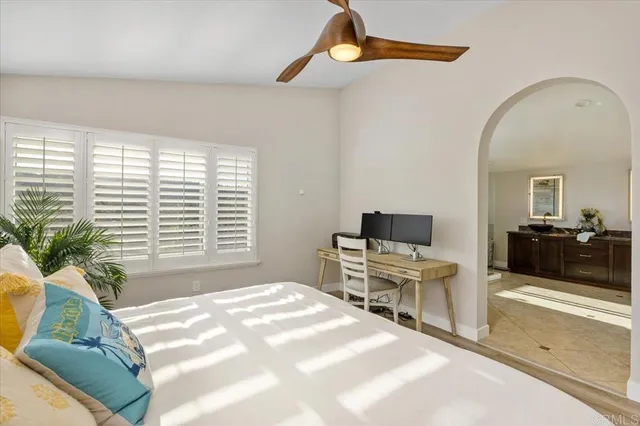 a bedroom with a bed and large windows