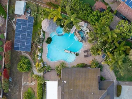 a view of backyard with a table and chairs under an umbrella