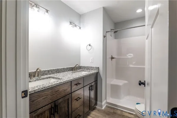 a bathroom with a granite countertop sink a shower and a mirror