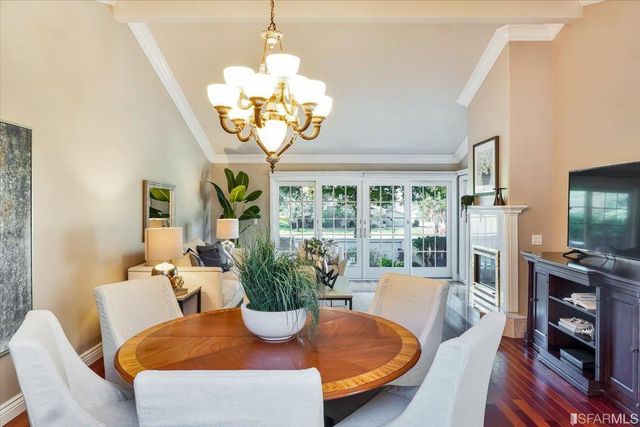 a kitchen with stainless steel appliances granite countertop a refrigerator a sink dishwasher a dining table and chairs with wooden floor