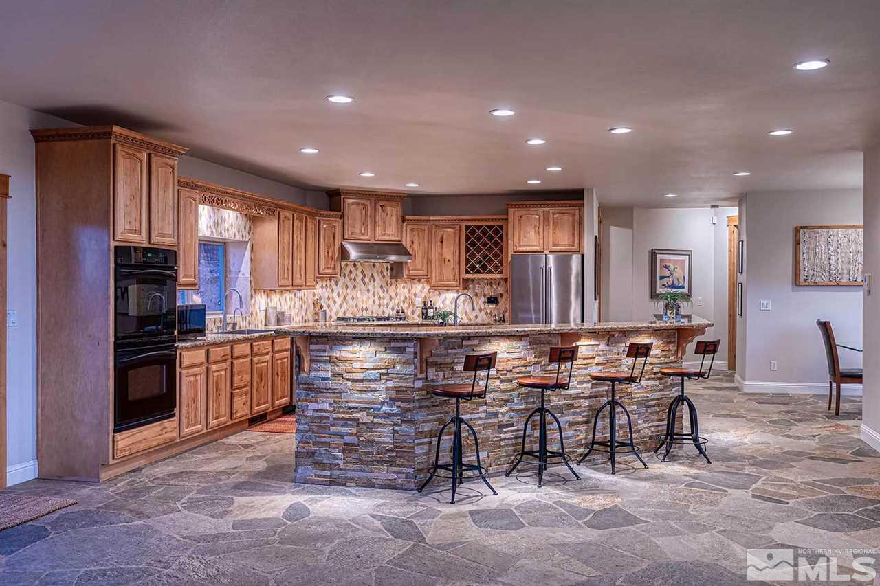 2001 Saddleback Road Reno, NV 89521 - Photo 8 of 25 a kitchen with stainless steel appliances kitchen island granite countertop a refrigerator and cabinets