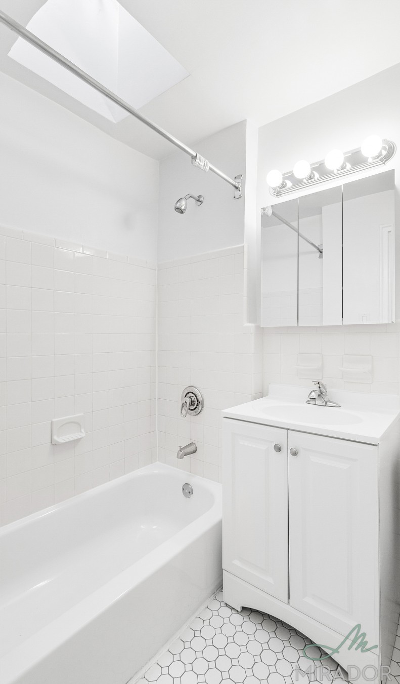 39 West 16th Street, Unit 5F Manhattan, NY 10011 - Photo 2 of 11 a bathroom with a bathtub a sink and a shower