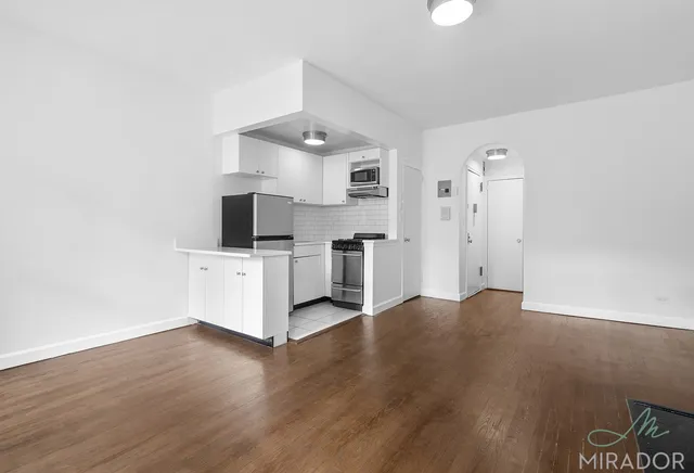 a view of kitchen with sink and refrigerator