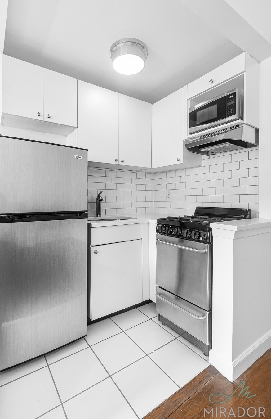 39 West 16th Street, Unit 5F Manhattan, NY 10011 - Photo 10 of 11 a kitchen with a stove microwave and sink