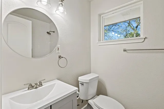 a bathroom with a toilet a sink and mirror