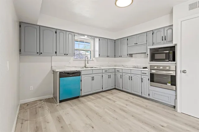 a kitchen with stainless steel appliances granite countertop a sink a stove a refrigerator with white cabinets