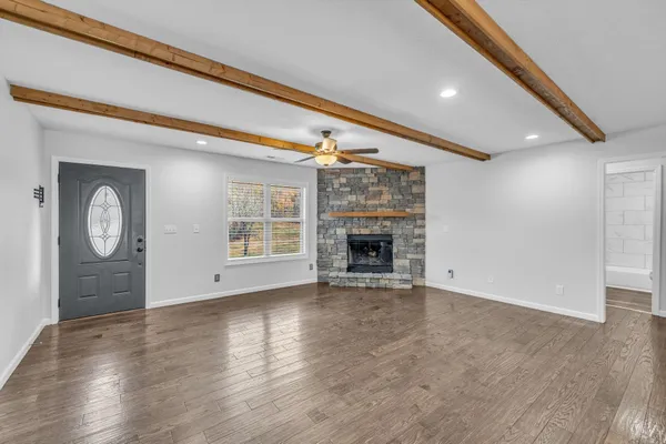 a view of an empty room with a window and a kitchen