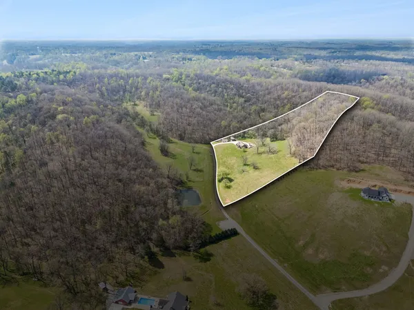 an empty room with wooden floor fireplace and windows
