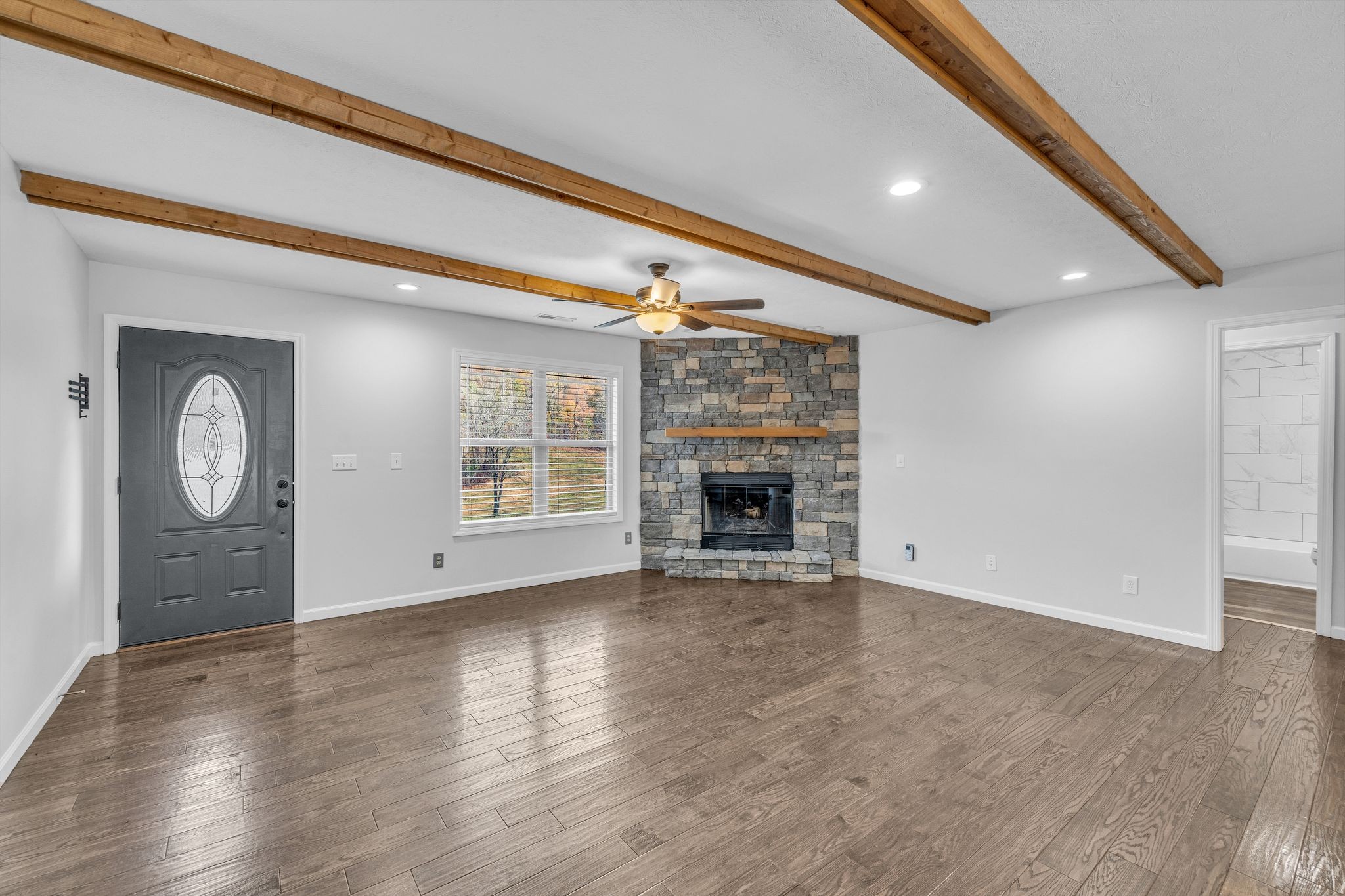 240 Scenic Drive Pulaski, TN 38478 - Photo 10 of 45 a view of an empty room with wooden floor fireplace and a window