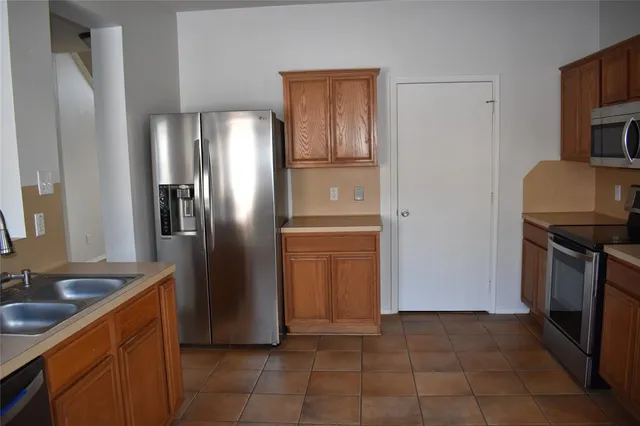 a kitchen with stainless steel appliances granite countertop a refrigerator and a stove