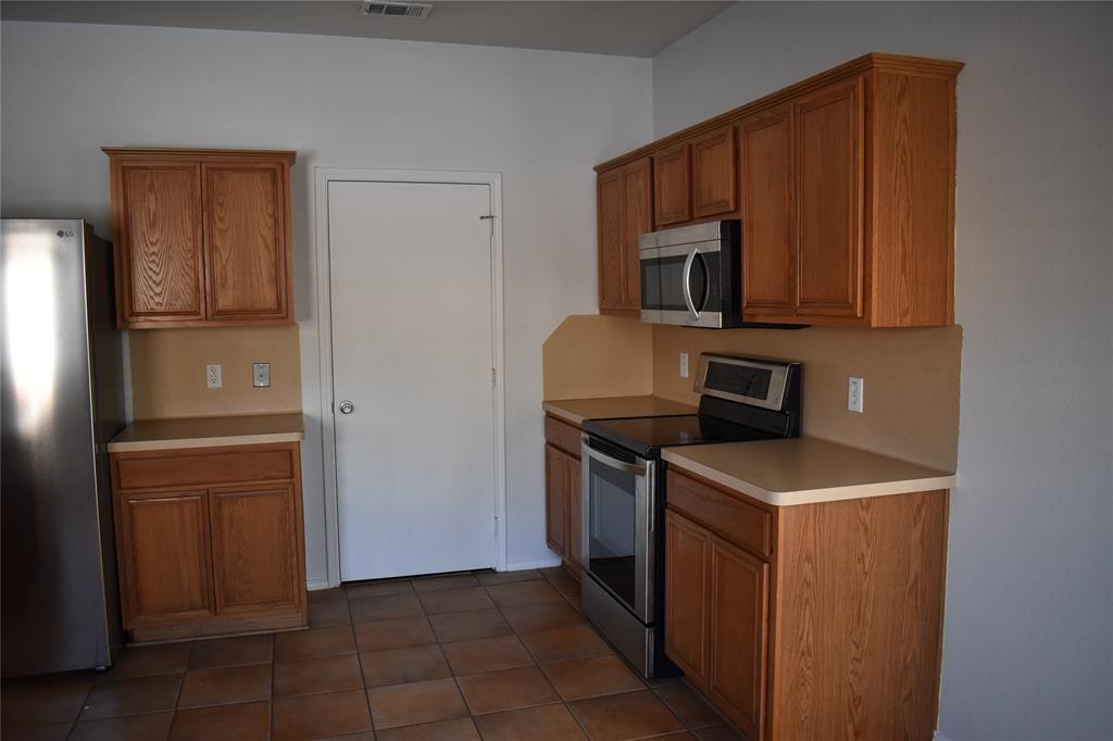 2026 Tanur Cascade Drive Anna, TX 75409 - Photo 3 of 24 a kitchen with stainless steel appliances granite countertop a refrigerator stove and microwave