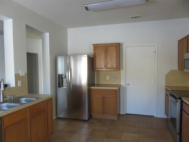 a kitchen with stainless steel appliances granite countertop a refrigerator and a sink