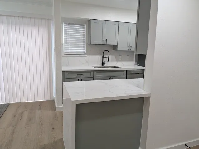 a kitchen with a sink a stove and cabinets