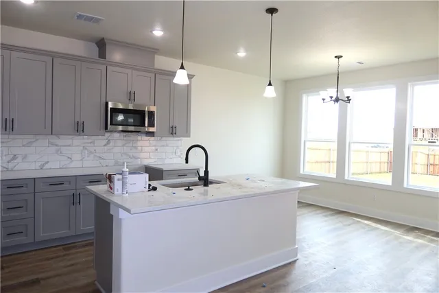 a kitchen with kitchen island a sink stainless steel appliances and cabinets