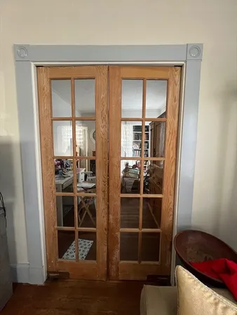 a view of a livingroom with wooden floor and a bathroom