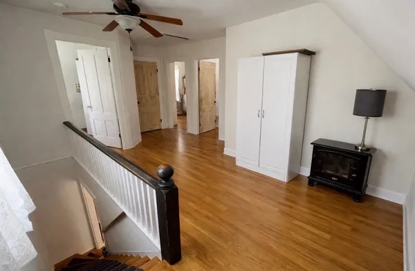 a view of a hallway with wooden floor and staircase