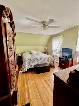 a bedroom with 2 bed and a flat tv screen on dresser