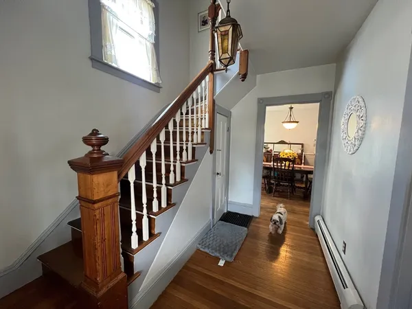a view of a hallway with wooden floor and stairs