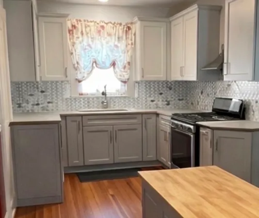 a kitchen with stainless steel appliances granite countertop a sink stove and cabinets