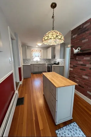 a view of a kitchen counter space a sink wooden floor and chandelier