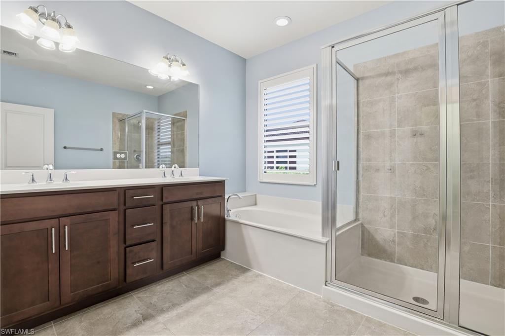 7894 Bristol Circle Naples, FL 34120 - Photo 16 of 29 a bathroom with a tub a sink and a mirror