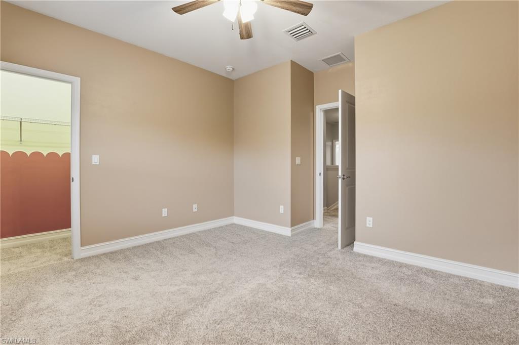 7894 Bristol Circle Naples, FL 34120 - Photo 18 of 29 an empty room with chandelier fan