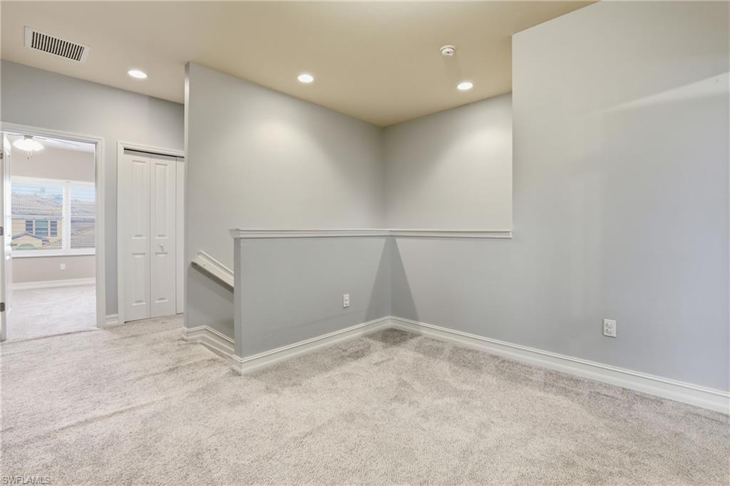 7894 Bristol Circle Naples, FL 34120 - Photo 22 of 29 an empty room with an entryway and wooden floor