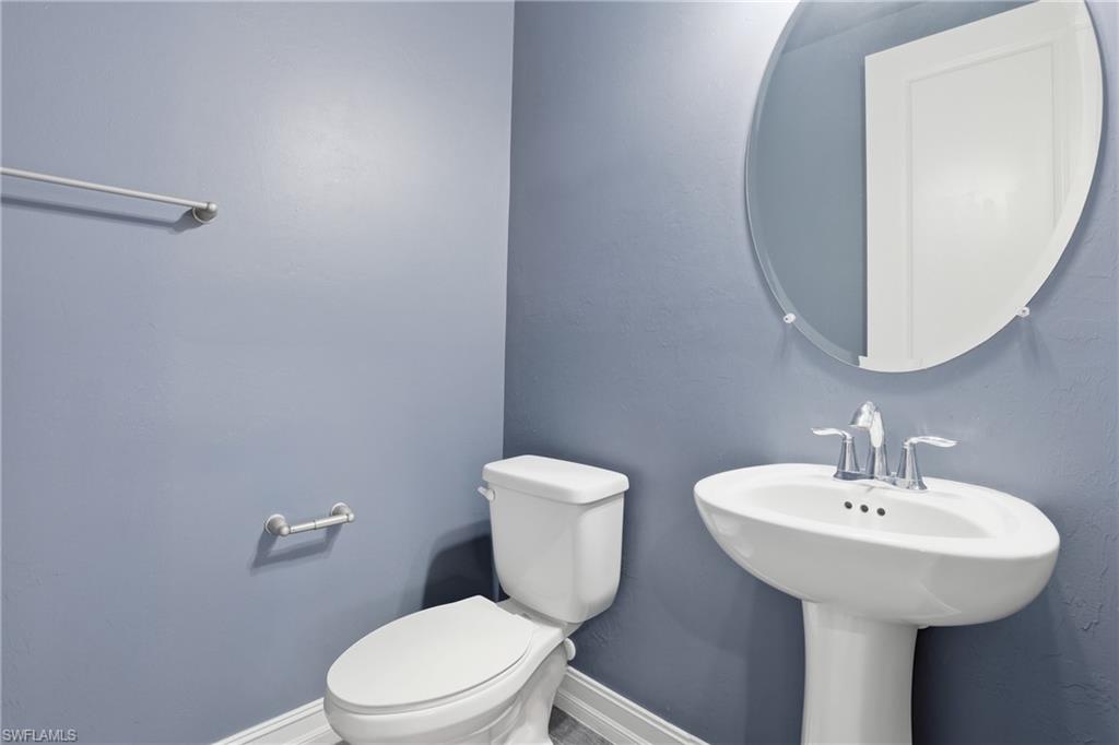 7894 Bristol Circle Naples, FL 34120 - Photo 24 of 29 a bathroom with a toilet sink and mirror