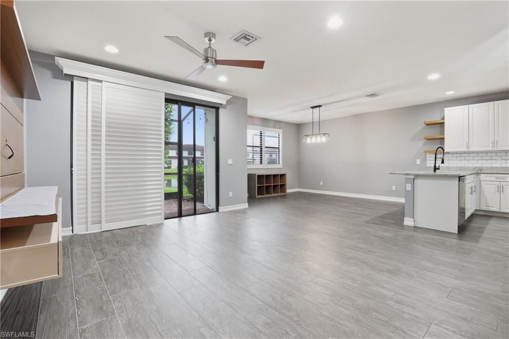7894 Bristol Circle Naples, FL 34120 - Photo 3 of 29 an empty room with wooden floor and windows