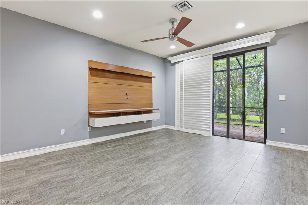 7894 Bristol Circle Naples, FL 34120 - Photo 4 of 29 a view of an empty room with wooden floor and a window