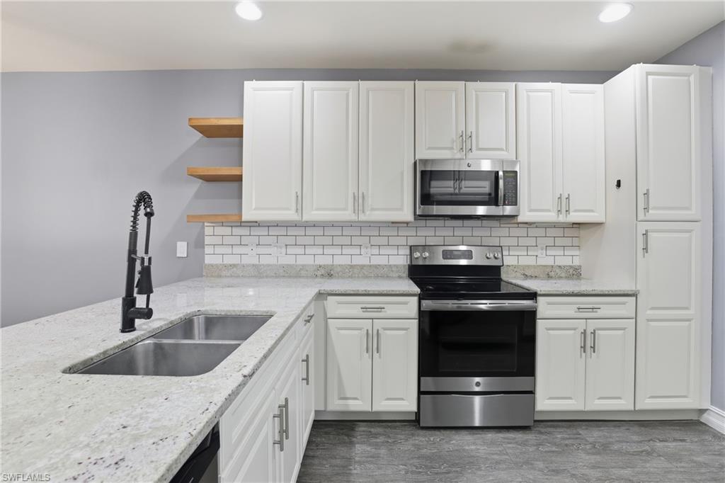 7894 Bristol Circle Naples, FL 34120 - Photo 9 of 29 a kitchen with granite countertop a sink and a stove
