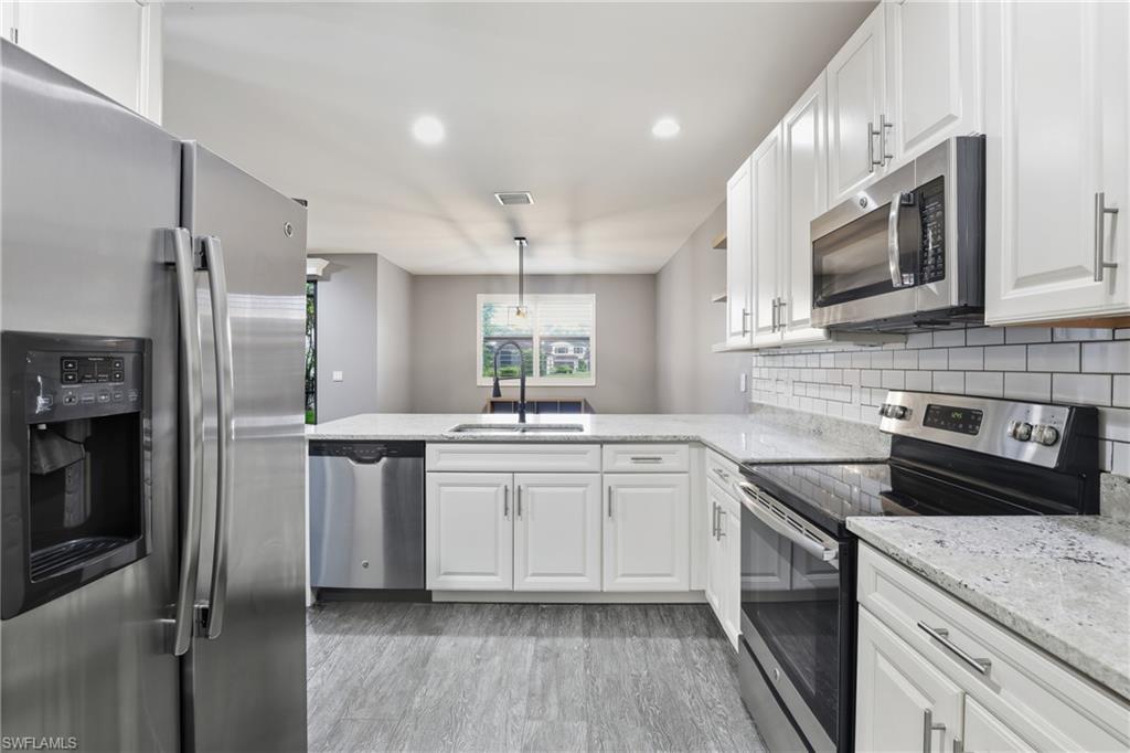 7894 Bristol Circle Naples, FL 34120 - Photo 10 of 29 a kitchen with a sink stove and refrigerator