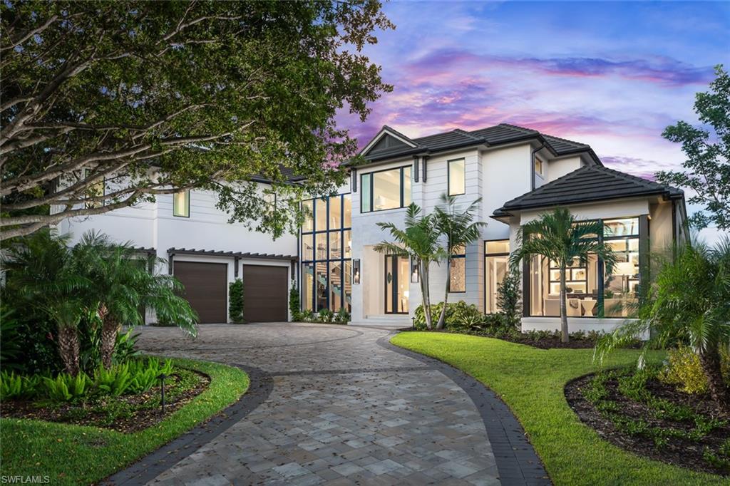 3131 Gin Lane Naples, FL 34102 - Photo 2 of 33 a front view of a house with a yard and potted plants