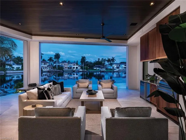a living room with patio furniture and a flat screen tv