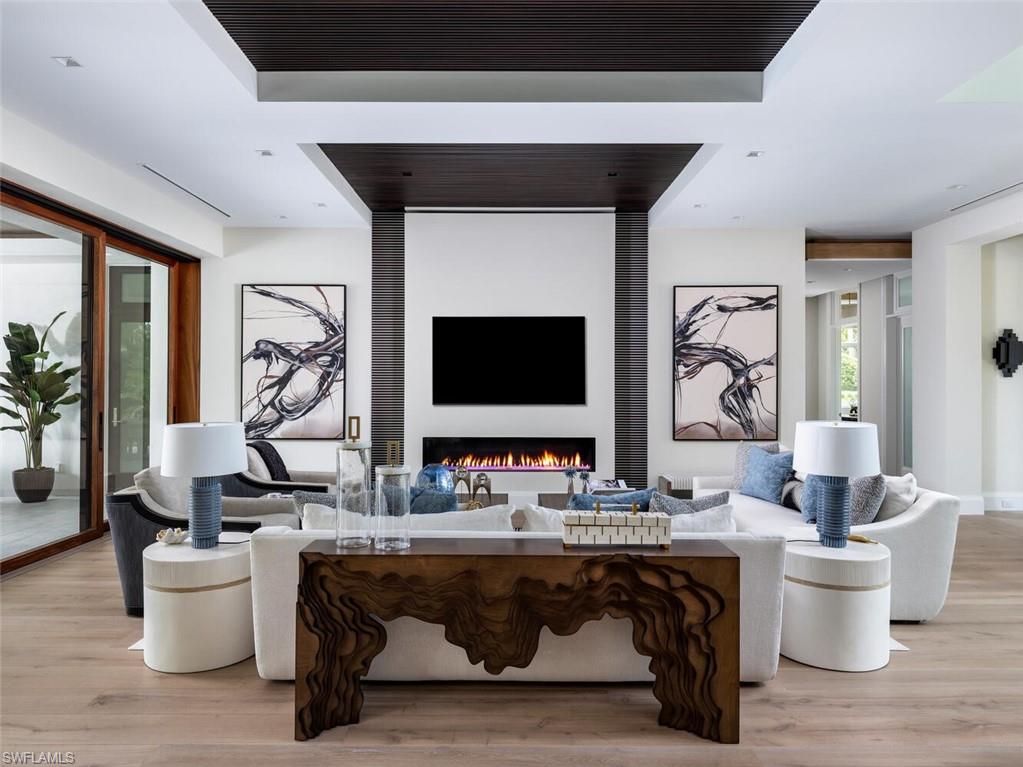 3131 Gin Lane Naples, FL 34102 - Photo 4 of 33 a living room with furniture a rug and a fireplace