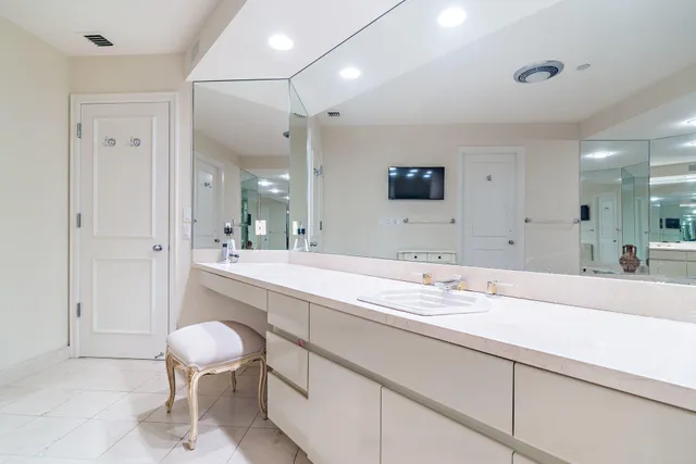 a bathroom with a sink a toilet and a large mirror