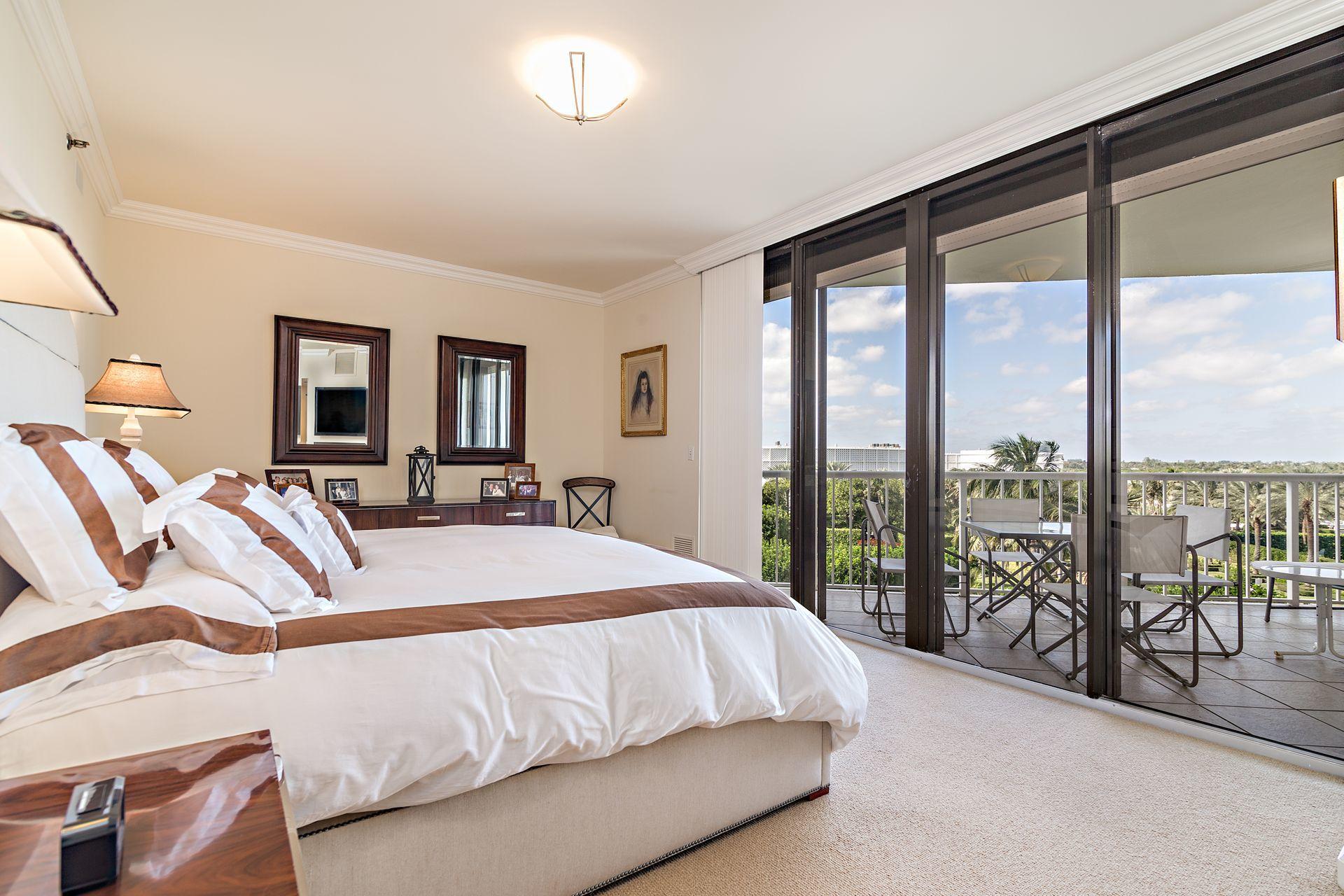 2770 South Ocean Boulevard, Unit 401S Palm Beach, FL 33480 - Photo 20 of 40 a bedroom with a large bed and a large window