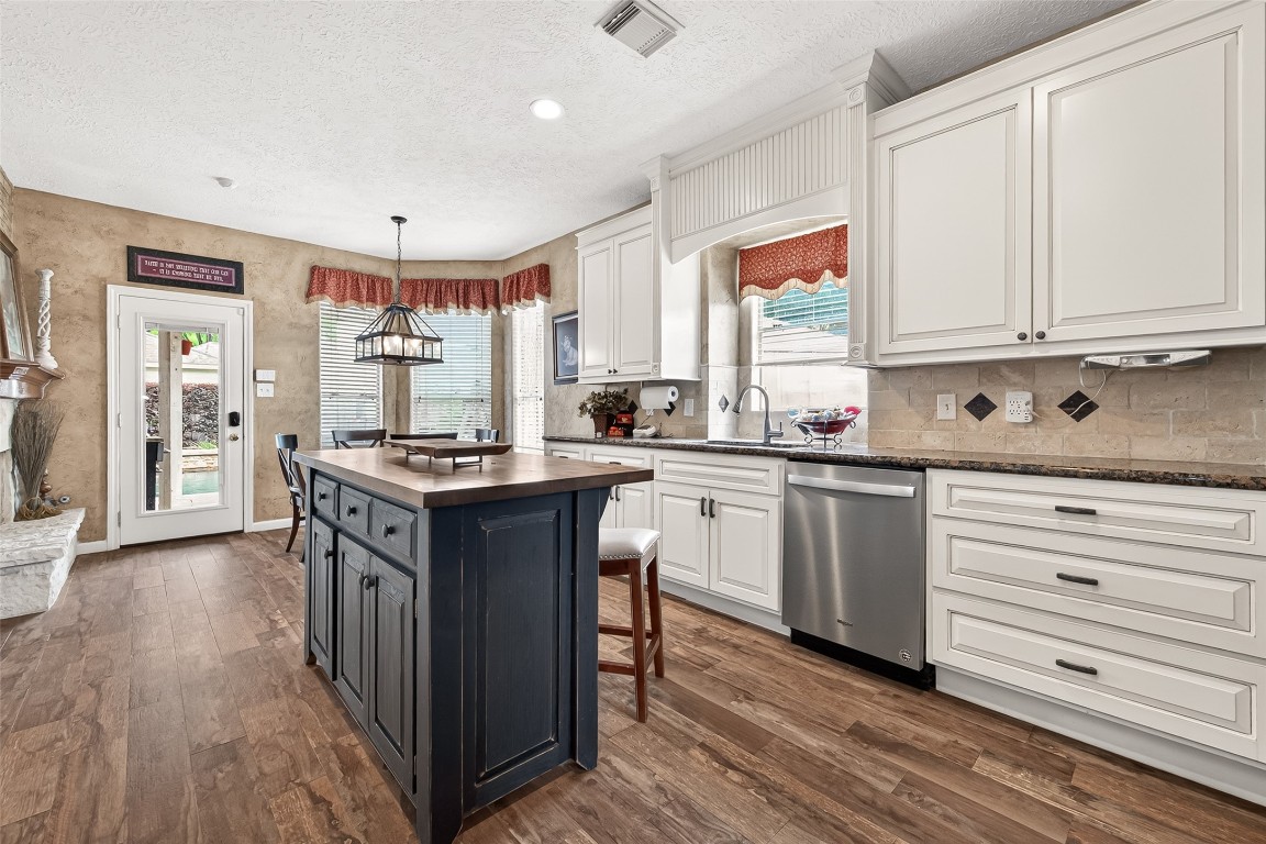 3506 Hunstanton Court Katy, TX 77450 - Photo 23 of 50 a kitchen with kitchen island granite countertop a sink cabinets and wooden floor