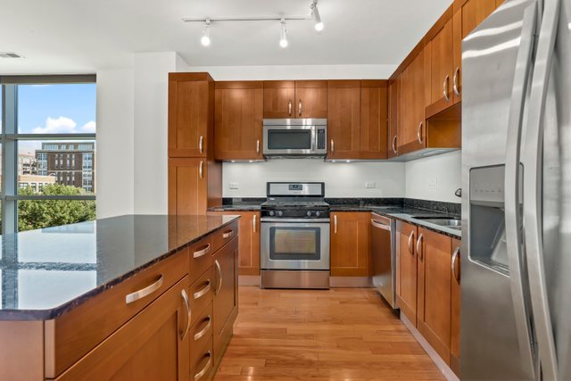 225 South Sangamon Street, Unit 412 Chicago, IL 60607 - Photo 12 of 29 a kitchen with stainless steel appliances granite countertop a refrigerator and a stove top oven