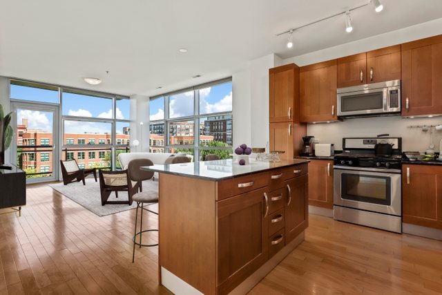 225 South Sangamon Street, Unit 412 Chicago, IL 60607 - Photo 2 of 29 a kitchen with stainless steel appliances granite countertop a stove top oven a sink dishwasher a dining table and chairs with wooden floor