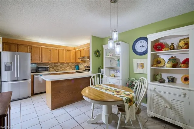 a kitchen with stainless steel appliances granite countertop a sink a stove a refrigerator and island
