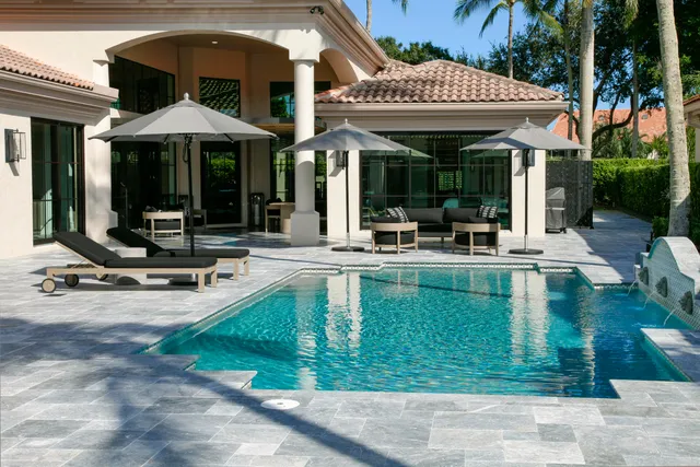 a front view of house with small garden and palm trees