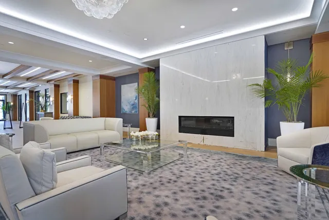 a view of a hallway with wooden floor and a living room