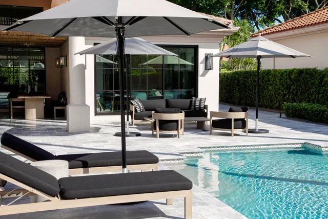 a view of patio with chairs and table under an umbrella