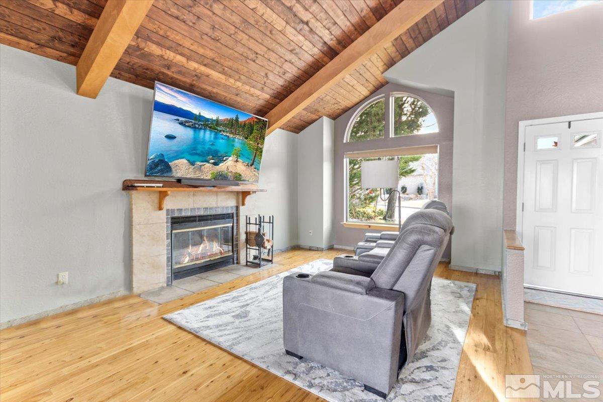 2616 Starr Meadows Loop Reno, NV 89519 - Photo 10 of 39 a living room with furniture a fireplace and a dining table with wooden floor